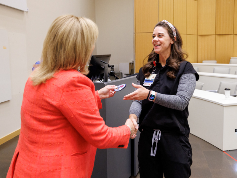 Clinical pharmacist Stephanie Tesseneer, right, receives a commemorative patch from Dr. LouAnn Woodward, vice chancellor for health affairs, during a ceremony to recognize Adult ED staff who stayed on the job for the duration of the pandemic.