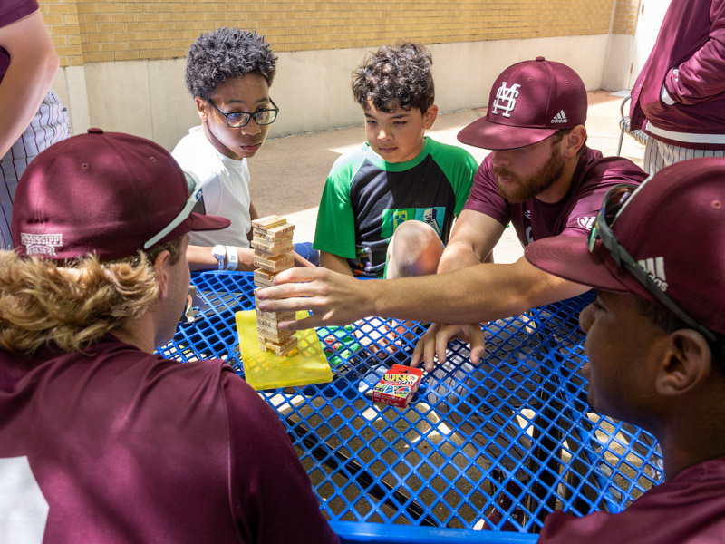 Children's of Mississippi patients Jamari Sykes and Jordan Porter watch as members of the Mississippi State baseball team play Jenga with them. Jay Ferchaud/ UMMC Communications