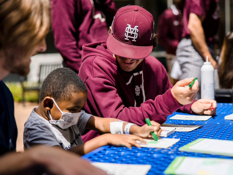 Children's of Mississippi patient Jayceston Harris enjoys coloring with Mississippi State University baseball players who stopped by on their way to Trustmark Park. Lindsay McMurtray/ UMMC Communications