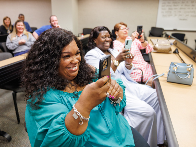 Kimberly Thomas, from left, mother of graduate William Bailey, Kimberly Bailey, William's aunt, and Corean Wheeler, William's grandmother, watch him accept his certificate during the ceremony.