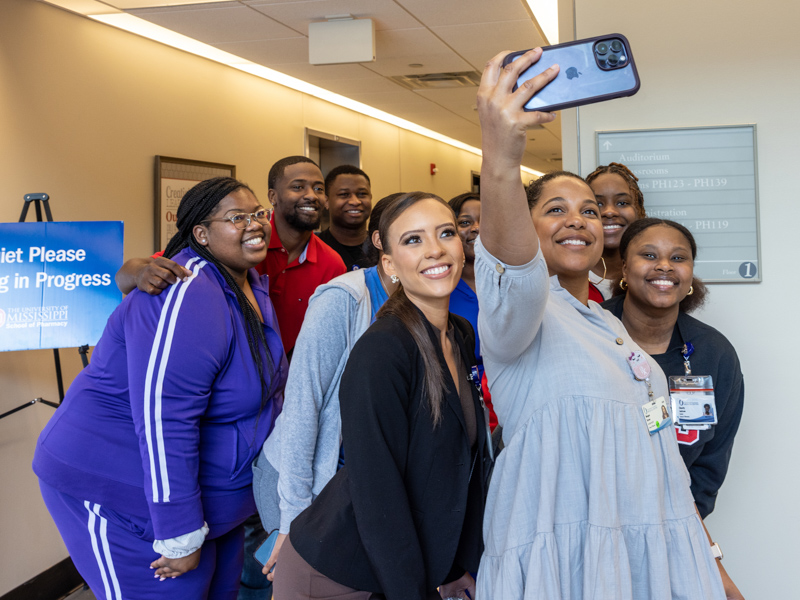 Miss Mississippi USA Sydney Russell smiles for a selfie with her classmates at the School of Pharmacy.