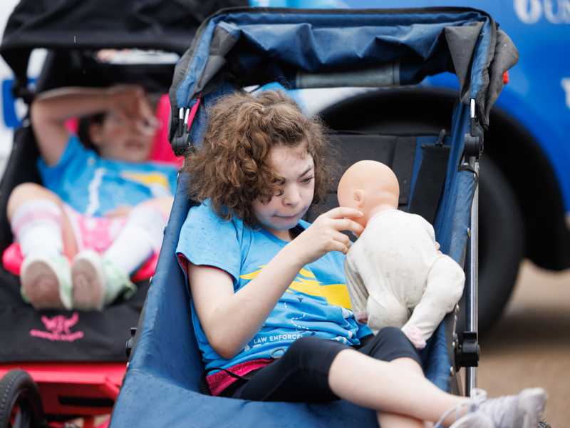 Elizabeth Guy plays with a doll before the start of the Law Enforcement Torch Run held at UMMC May 10.