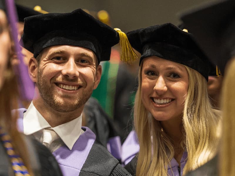 School of Medicine graduates Austin Troy Dillon and Codi Ballard Echols can't help but smile during commencement.