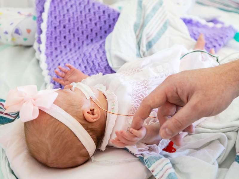 Dad Shawn Ladner touches the hand of daughter Everleigh Rose Ladner.