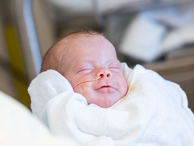 Adalyn Elizabeth Ladner smiles after enjoying a bottle feeding.