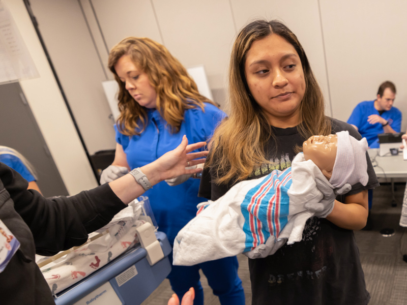 Mirzait Sanchez, right, a recent East Central Community College nurse graduate, holds a simulated newborn during STORK training. Behind her is fellow STORK trainee and Baptist Hospital Jackson ER nurse Merrell Hourguettes.