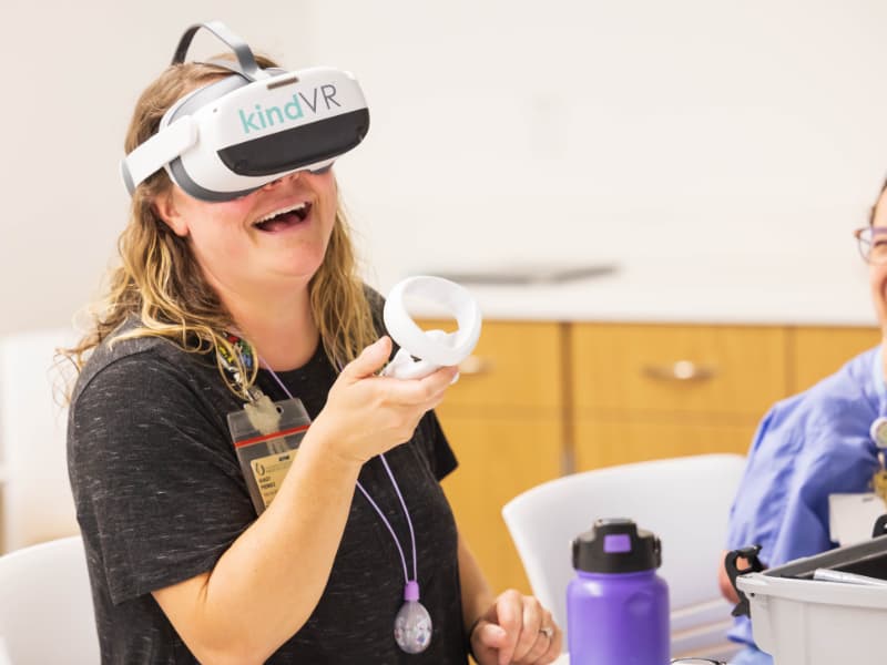 Child life specialists Ashley Prendez, left, and Avery Friedmann share a laugh during KindVR training.