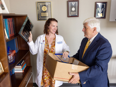 Murphy helps Dr. Joey Granger, her predecessor and mentor, pack up some of his awards before retiring as SGSHS dean in June.