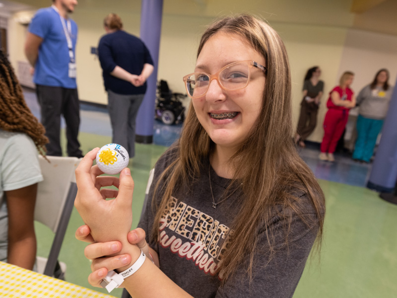 Makayla Jones of Moss Point shows the golf ball she decorated during an afternoon of golfing fun at Children's of Mississippi.