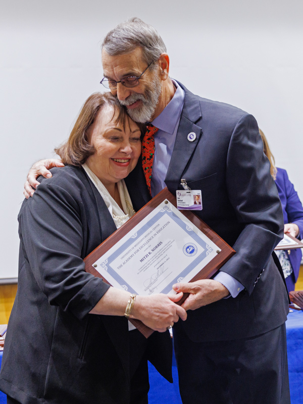 Dr. Mitzi Norris, left, executive director for academic compliance, effectiveness and institutional research, and a member of the Doctor of Health Administration faculty in the School of Health Related Professions, is welcomed to the academy by fellow inductee, Dr. Rob Rockhold, professor emeritus of pharmacology/toxicology and chair of the academy's membership committee.