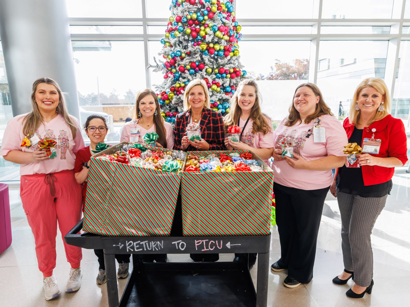 Thanking Mississippi First Lady Elee Reeves, center, for her Christmas gift donation to Children's of Mississippi patients and their families are, fromleft, child life specialists Allyson Holliman and Avery Friedmann, child life manager Cara Williams, child life specialist Madeline Wilson, project manager Olivia Ulbricht, and Meredith Aldridge, executive director of the Office of Development at UMMC. Melanie Thortis/ UMMC Photography