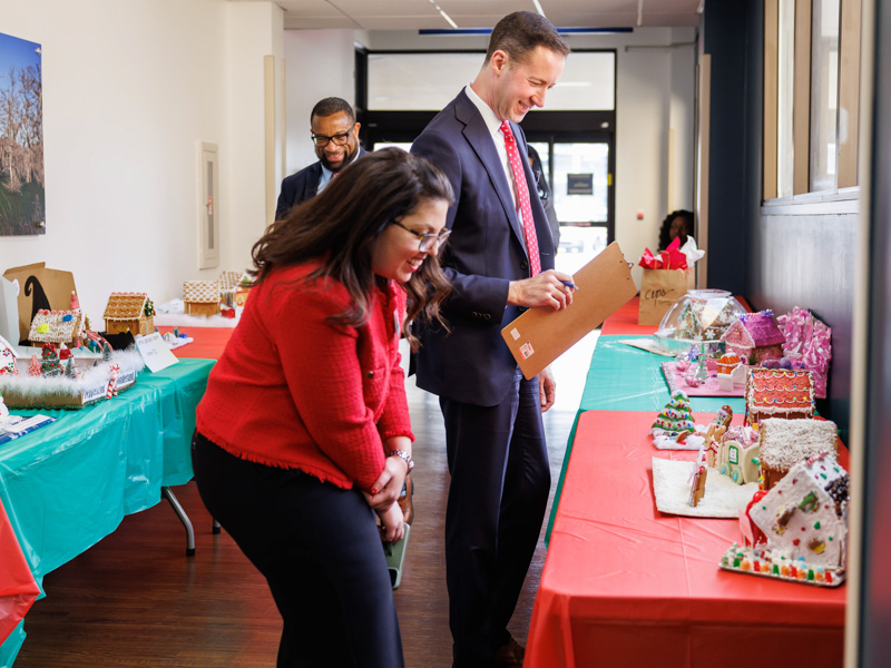 Judges admire the handiwork of gingerbread houses vying for top honors in UMMC's annual holiday competition. Melanie Thortis/ UMMC Photography