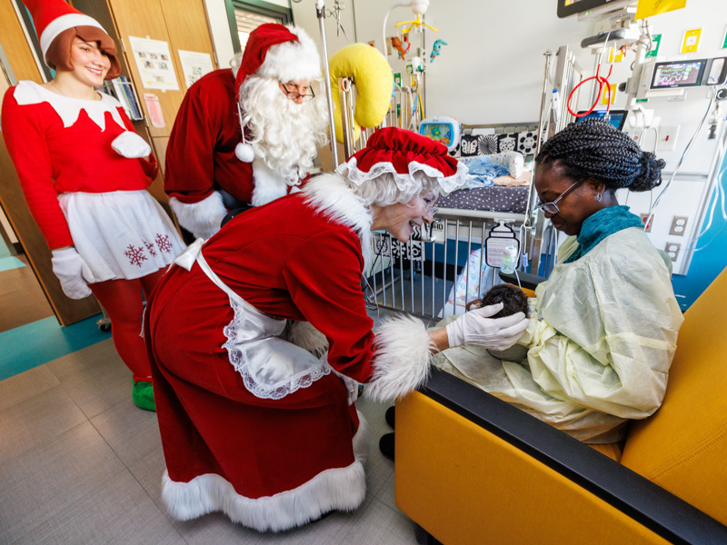 Mrs. Claus, the Elf on the Shelf and Santa visit Adam Kwarteng of Hattiesburg and his mom, Ramata Sakhanokoho, at Children's of Mississippi. Jay Ferchaud/ UMMC Photography 