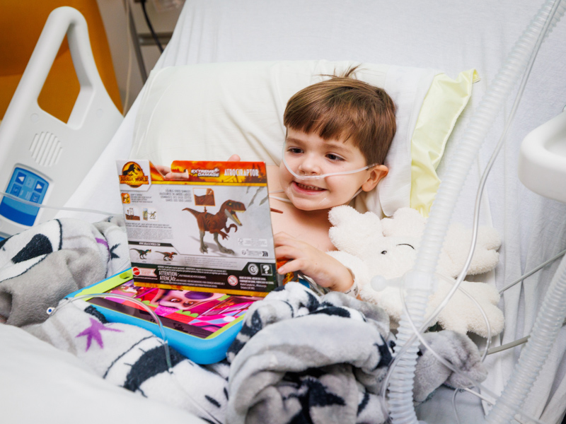 Children's of Mississippi patient Shepherd Snow of Hattiesburg smiles while playing with an early Christmas gift. Jay Ferchaud/ UMMC Photography