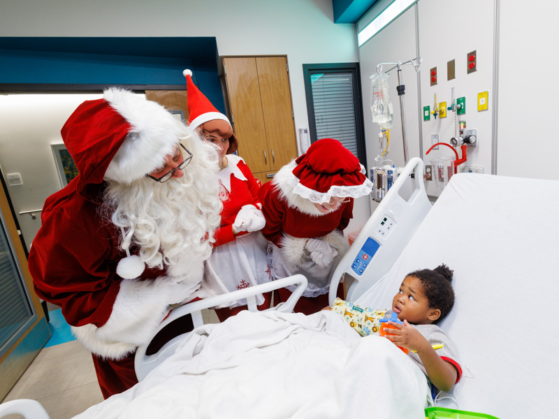 Children's of Mississippi patient Christopher Roberts of Florence gets a visit from Santa, an elf and Mrs. Claus at the Kathy and Joe Sanderson Tower. Jay Ferchaud/ UMMC Photography 