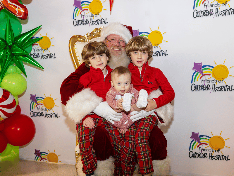 Smiling with Santa at BankPlus Presents Light-A-Light are, from left, Howard, Mance and Bobby Hosemann.