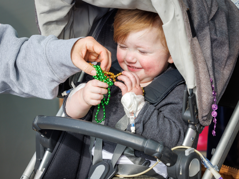 Children's of Mississippi patient Sam McGaugh of Madison smiles after catching Mardi Gras beads.