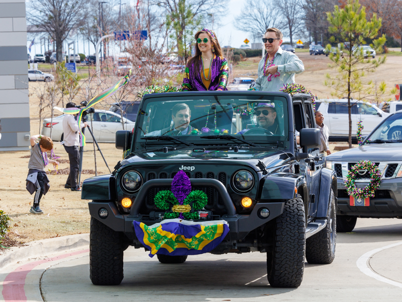Decorated vehicles from Jeeps to police motorcycles paraded by the Kathy and Joe Sanderson Tower at Children's of Mississippi in anticipation of Mardi Gras.
