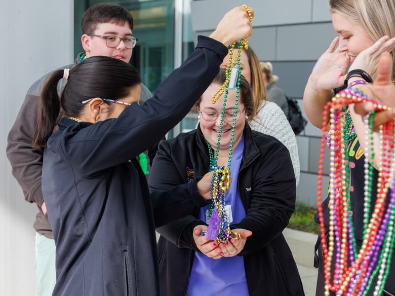 Children's of Mississippi care team members untangle Mardi Gras beads after the Mississippi Department of Public Safety Mardi Gras parade Feb. 7.