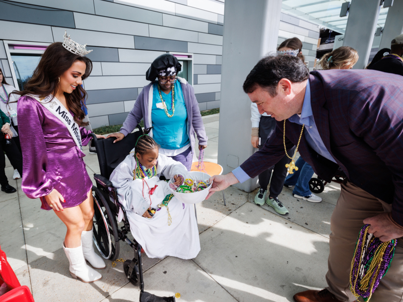 Children's of Mississippi patient Ashanti Blockmon of Jackson picks Mardi Gras treats offered by Mississippi Commissioner of Public Safety Sean Tindell.