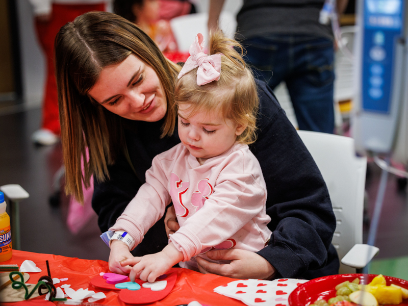 Children's of Mississippi patient Adley Thomas and her mom, Madison, of Rayville, Lousiana, work on a Valentine's Day art project. Jay Ferchaud/ UMMC Photography 