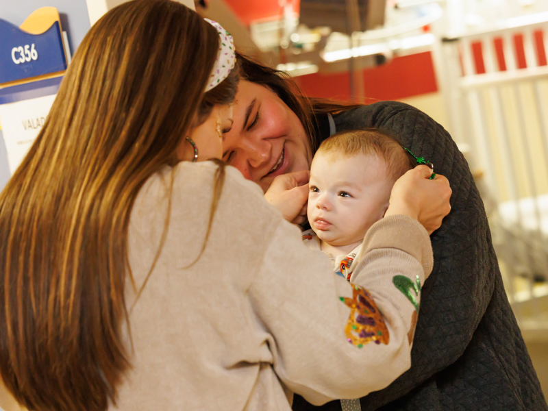 Child life manager Cara Williams gives Children's of Mississippi patient Rhett Valadie some beads during a Friends of Children's Hospital Mardi Gras parade Tuesday. Melanie Thortis/ UMMC Photography 