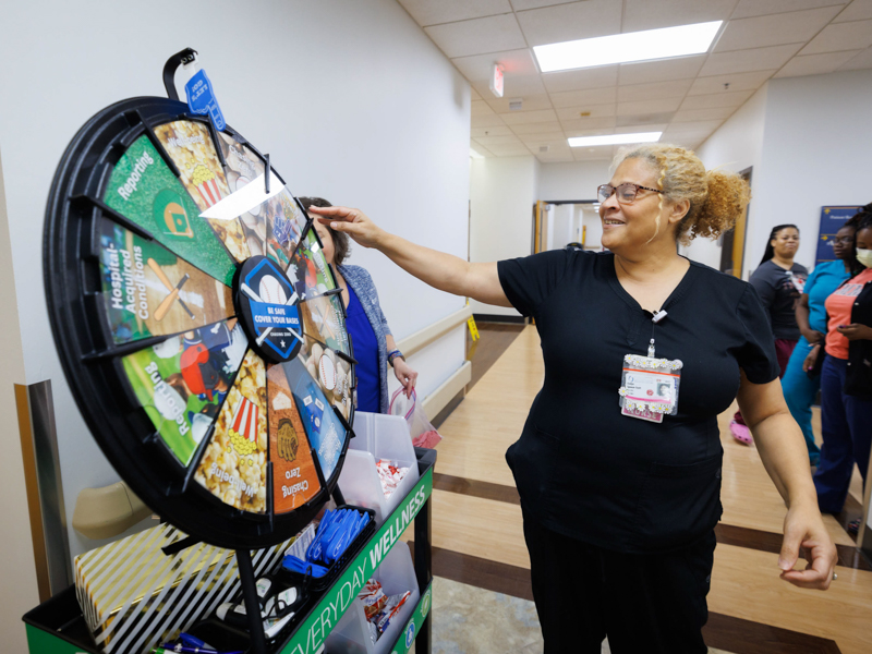 Registered Nurse Evelyn Spencer-Scott takes a spin on the Safety Wheel for a chance to win prizes as the wheel made a stop at 3 Wiser as part of Patient Safety Week activities.