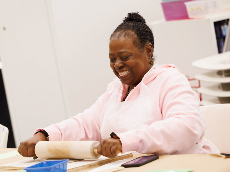 Trese Evans rolls out her lump of clay before shaping it into a piece of art during the March session of Art in Mind. "[Susan Anand] brings out your artistic side," she says.