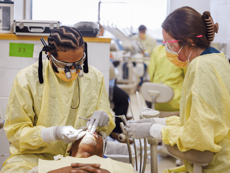 Winters treats patient Steve Hudson of Canton, assisted by third-year dental student, Bailey Steen.