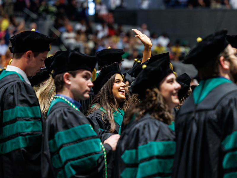 School of Medicine graduate Jessica McClain is either trying to high-five the coliseum roof or waving at her supporters, or both.