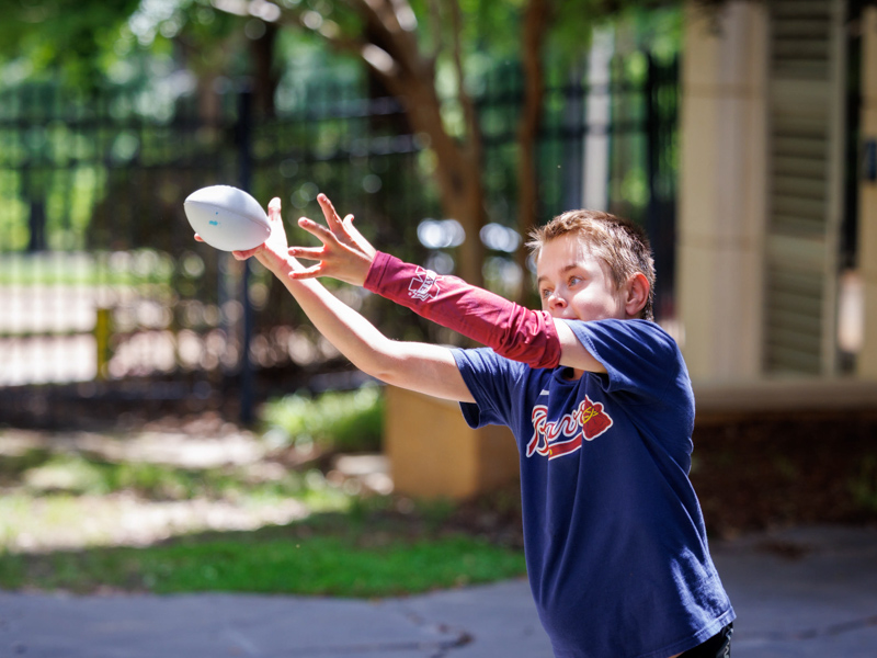 Sawyer Dykman, of Florence, a patient at Children's of Mississippi, fields a ball during the MSU baseball team's visit to the facility.