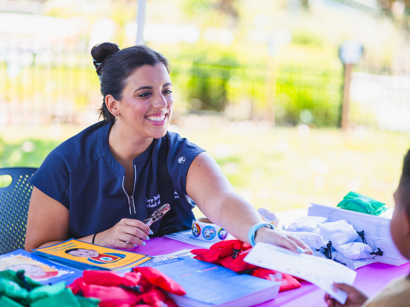 Fourth-year dental student Mary Beth Gillespie punches a child's card during health screenings.