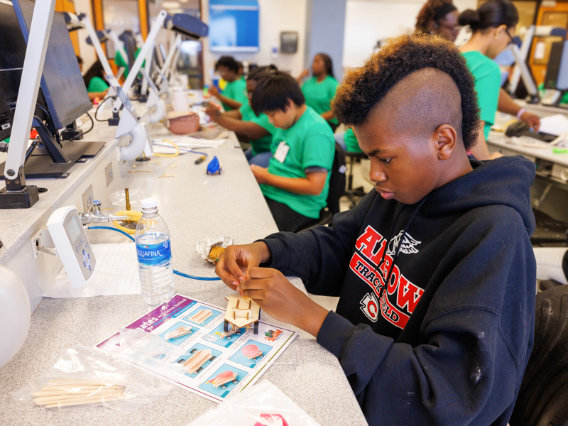 Daniel Dolsen assembles a wind-powered vehicle during S.M.I.L.E. U activities.