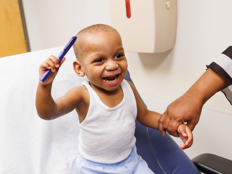 Kobe Abron smiles while holding a pen shortly after his cast was removed.
