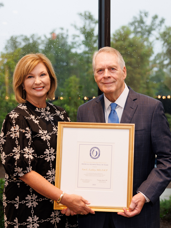 Medical Hall of Fame inductee, Dr. Van Lackey, receives the award from Dr. LouAnn Woodward.