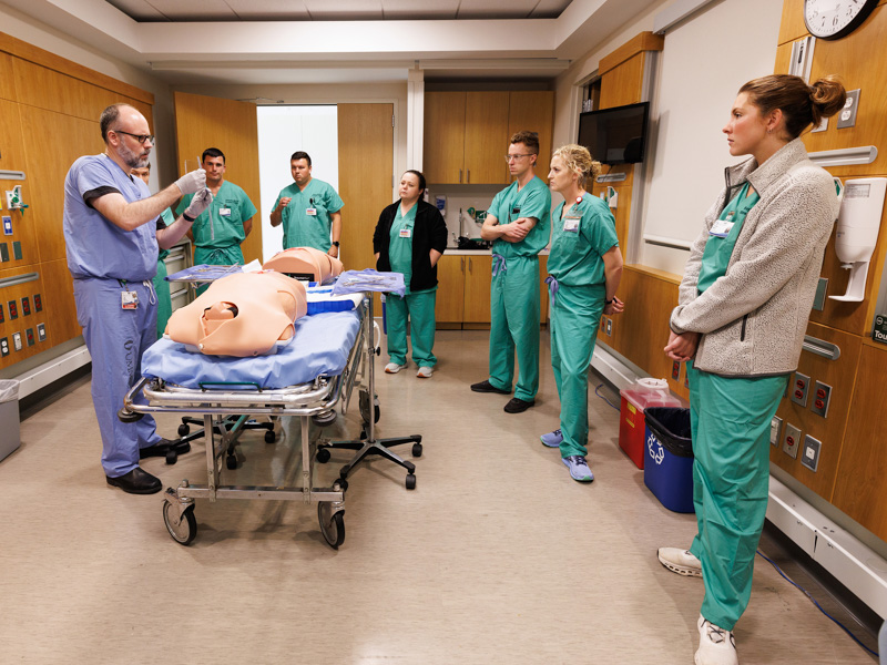 Dr. Joseph Doherty, left, assistant professor of emergency medicine, trains new residents in inserting a chest tube. Jay Ferchaud/ UMMC Communications 
