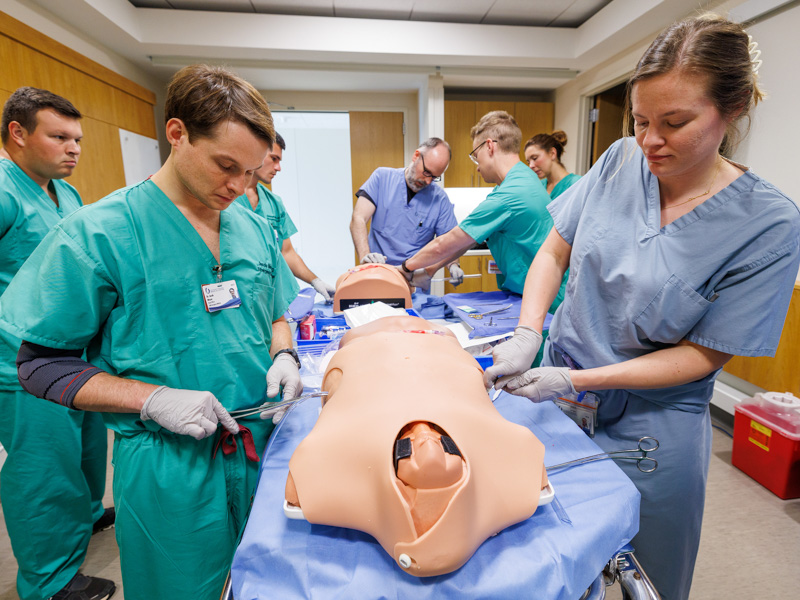 Residents Jacob Meyer and Angelica Walinski practice inserting a chest tube. Jay Ferchaud/ UMMC Communications 