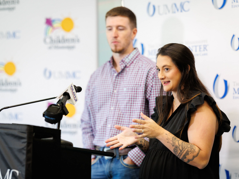 Ashley Meyers speaks to news media as husband Tyler Meyers looks on.