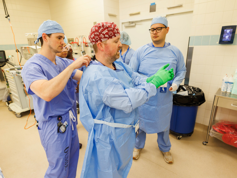 Surgery resident Dr. Kyle Deivert, left, helps surgical tech James Burnett during training for new residents at the University of Mississippi Medical Center. Lookin on is surgery resident Dr. Humberto Aparicio. Melanie Thortis/ UMMC Communications 