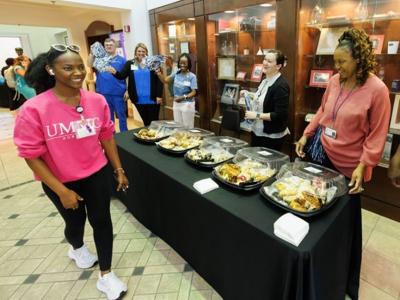 Nursing student NyDaisha Dortch is all smiles as faculty and staff welcome students back with a grab-and-go breakfast at the beginning of the fall semester. The School of Nursing saw the biggest enrollment gains among campus schools. Melanie Thortis/ UMMC Communications
