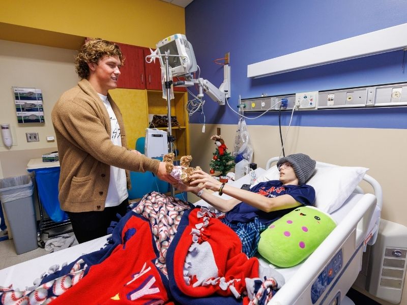 Children's of Mississippi patient Traye Moran of Kiln receives a Nicholas Air bear from Ole Miss quarterback Jaxson Dart.