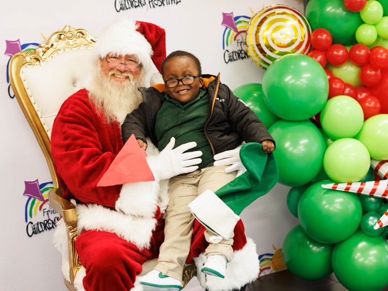 Children's of Mississippi patient Keymani Johnson of Jackson smiles with Santa. Melanie Thortis/ UMMC Communications