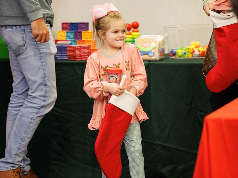 Madalyn Smith of Brookhaven fills a Christmas stocking with gifts from Friends of Children's Hospital. Melanie Thortis/ UMMC Communications