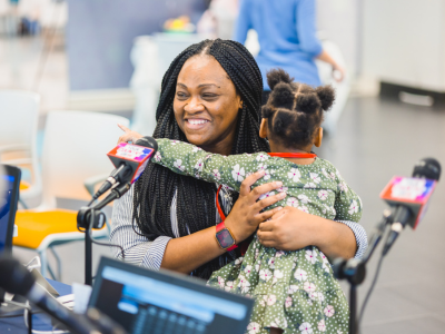 Jessica Carter of Jackson hugs daughter Lyndsey Lee Carter while talking with on-air personalities during the 2023 Mississippi Miracles Radiothon.