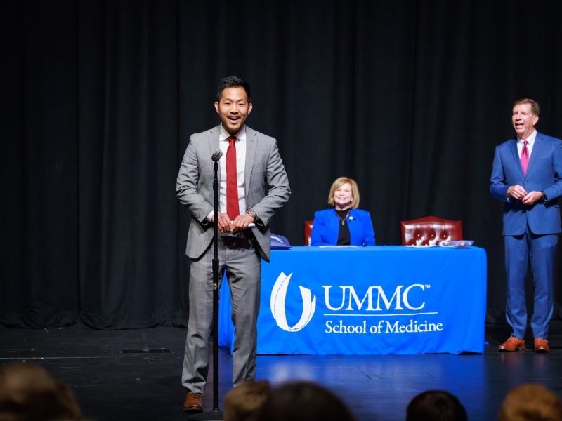 Wesley Zhang announces his match: orthopaedic surgery at Henry Ford Health Science Center in Detroit, Michigan. Looking on are Dr. LouAnn Woodward, vice chancellor for health affairs and dean of the School of Medicine, and Dr. Michael McMullan, associate dean for student affairs in the School of Medicine.