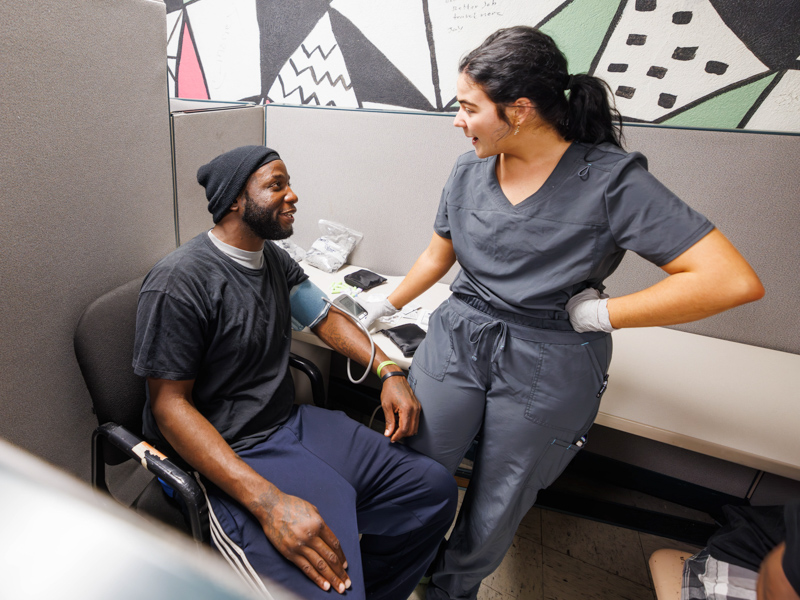 At Stewpot Opportunity Center, BSN student Bryce Harrison takes time to get to know Ira Williams of Jackson.