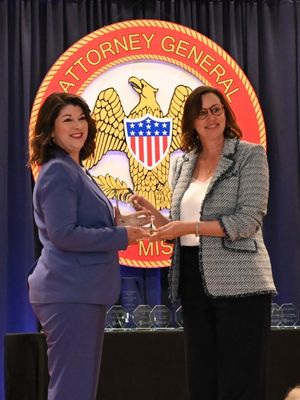 Brandi Fischer, left, receives the 2025 Outstanding Service to Crime Victims Award from Karla Tye, CEO of Children's Advocacy Centers of Mississippi.