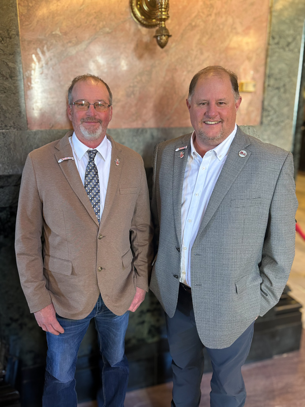 Roy Holder, left, Log-A-Load For Kids Volunteer of the Year, is congratulated by David Livingston, executive director of the Mississippi Loggers Association, after being honored by the Mississippi Legislature.