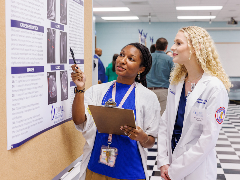 Smith looks over a poster at SHRP Research Day on April 25 with Master of Science in Magnetic Resonance Imaging student Jordan Pritchard.
