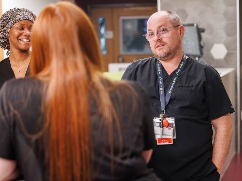Michael Jones, nurse educator, talks with colleagues at the NICU in the Sanderson Tower Melanie Thortis/ UMMC Communications